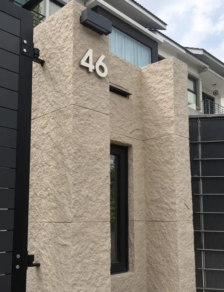 Modern villa entrance finished with beige flexible faux stone panels on a textured exterior gate wall