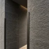 Graphite Current Flowing Stone Texture Interior Wall | YITA Graphite Current Flowing Stone Texture applied to a dark modern interior wall with layered horizontal stone relief