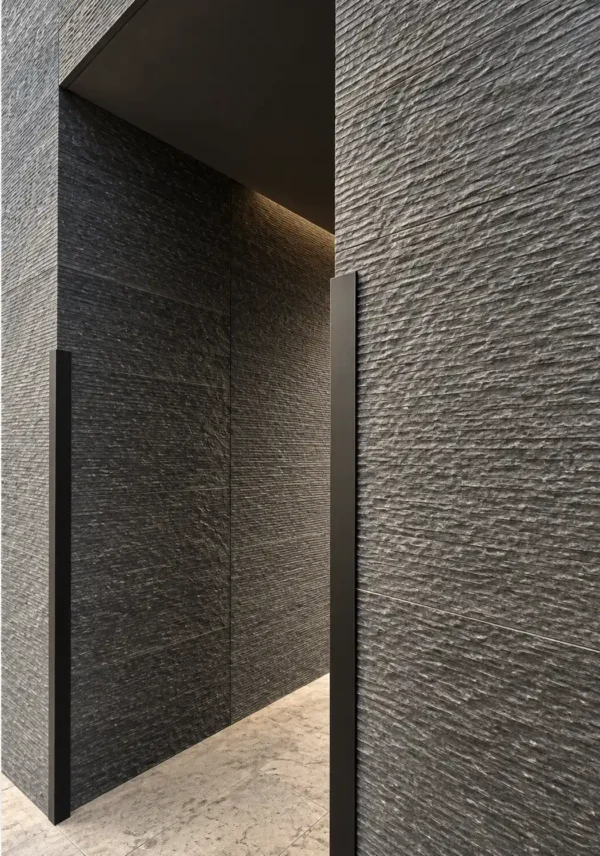 Graphite Current Flowing Stone Texture Interior Wall | YITA Graphite Current Flowing Stone Texture applied to a dark modern interior wall with layered horizontal stone relief