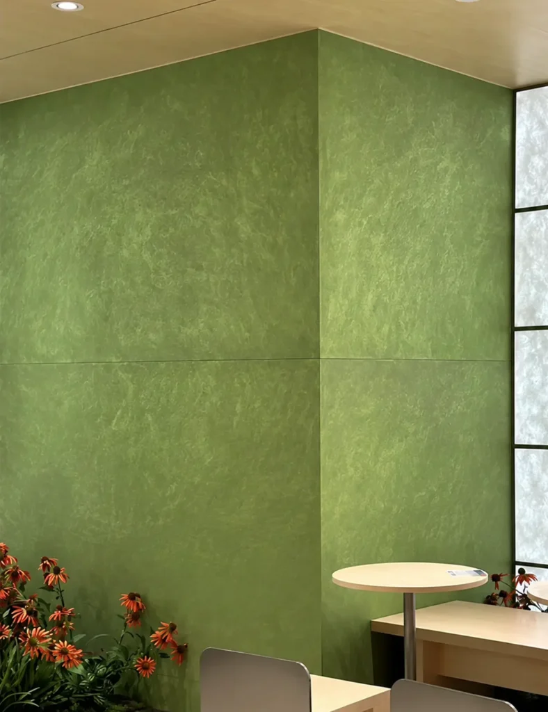 Green textured wall in a modern commercial interior with café seating