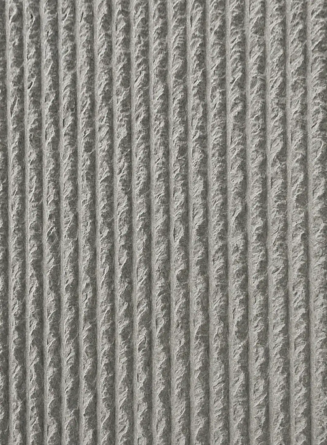 Gray ribbed stone surface with deep vertical carved grooves | YITA
