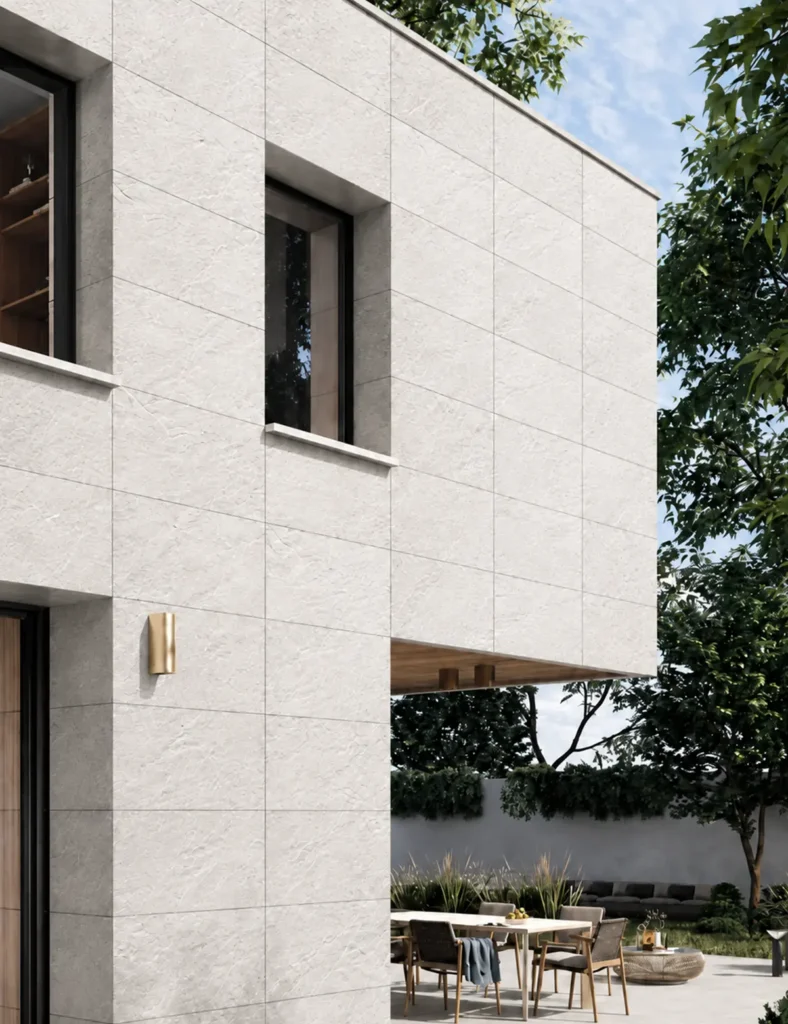 Modern house exterior finished with off-white flexible faux stone panels in a clean large-format facade layout