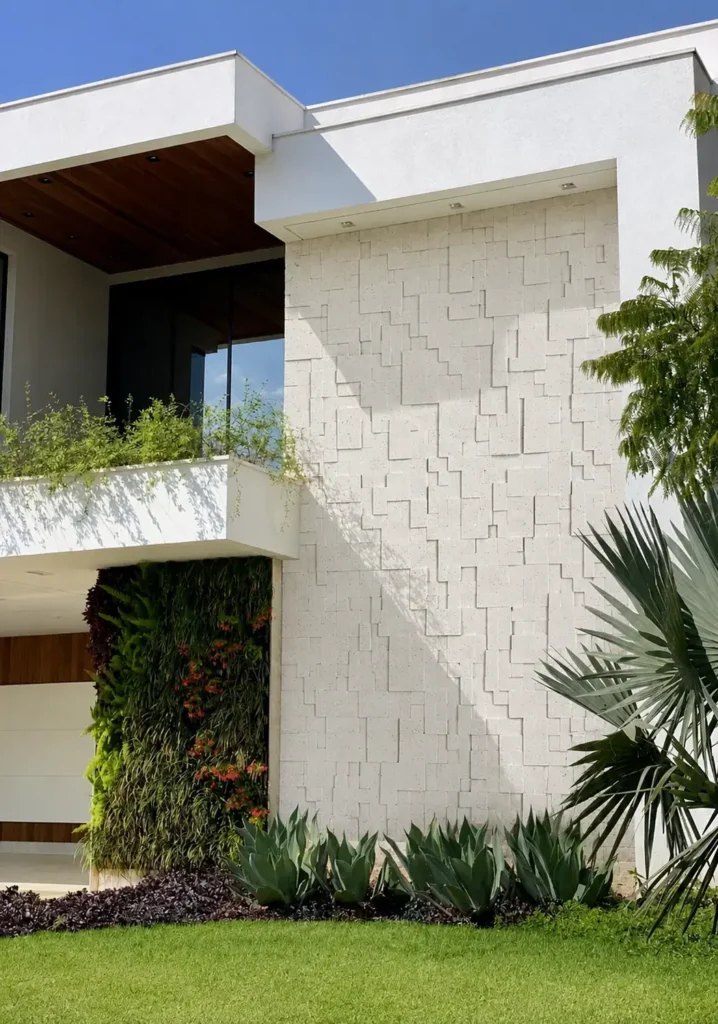 Patterned travertine exterior accent wall on a modern residence with geometric stone detailing