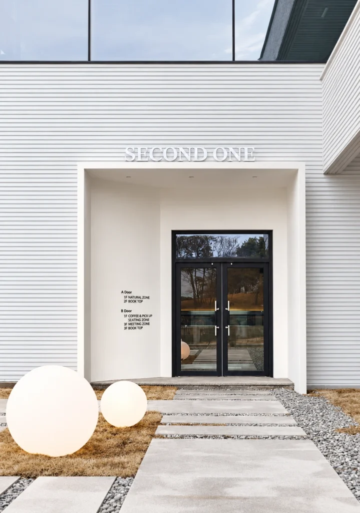 Pearl White Large Ripple fluted wall panels applied to a modern commercial entrance facade