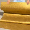 Golden silk metallic flexible stone sheet shown in a rolled display