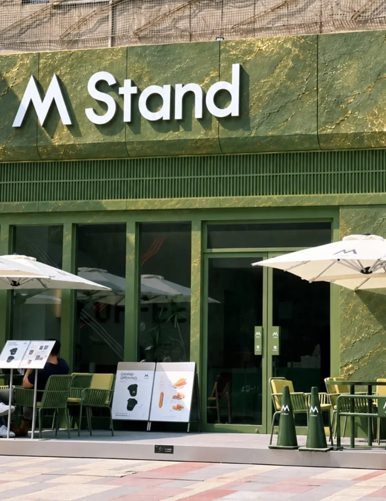 Green gilded flexible stone veneer applied on a cafe storefront facade with metallic texture