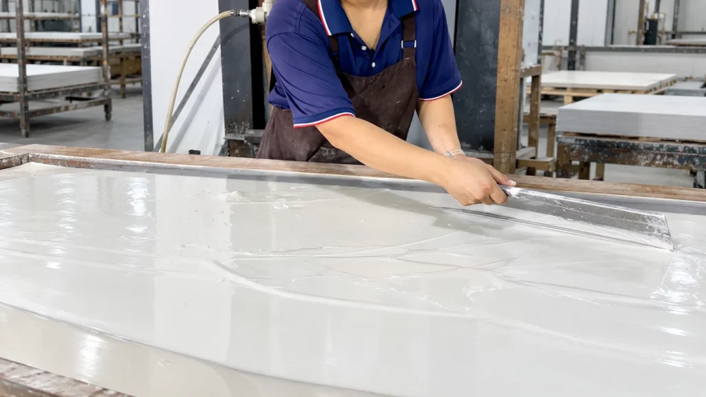 Worker spreading clean mineral slurry during flexible stone production