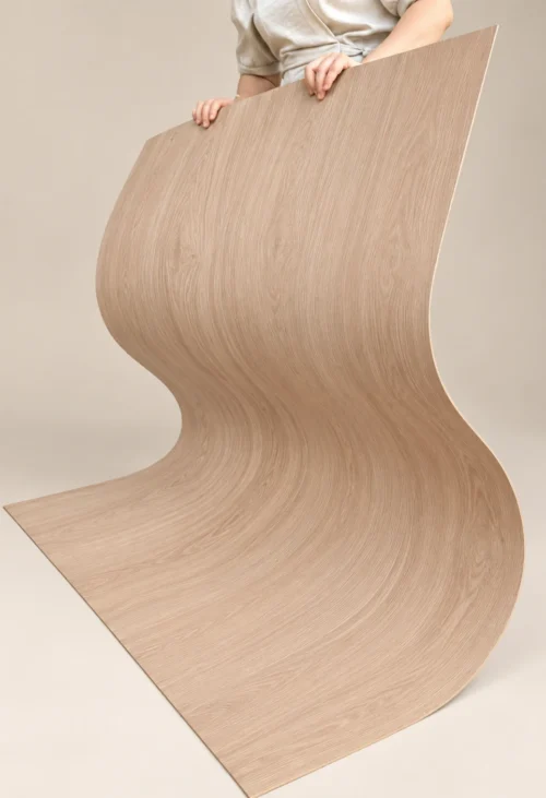 Natural Oak Wood Grain Flexible Panel | YITA Person holding a natural oak wood grain flexible panel in an S-shaped curve, showing its flexibility and fine wood texture.