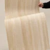 Natural wood grain flexible stone sheet bent by hand to show material flexibility