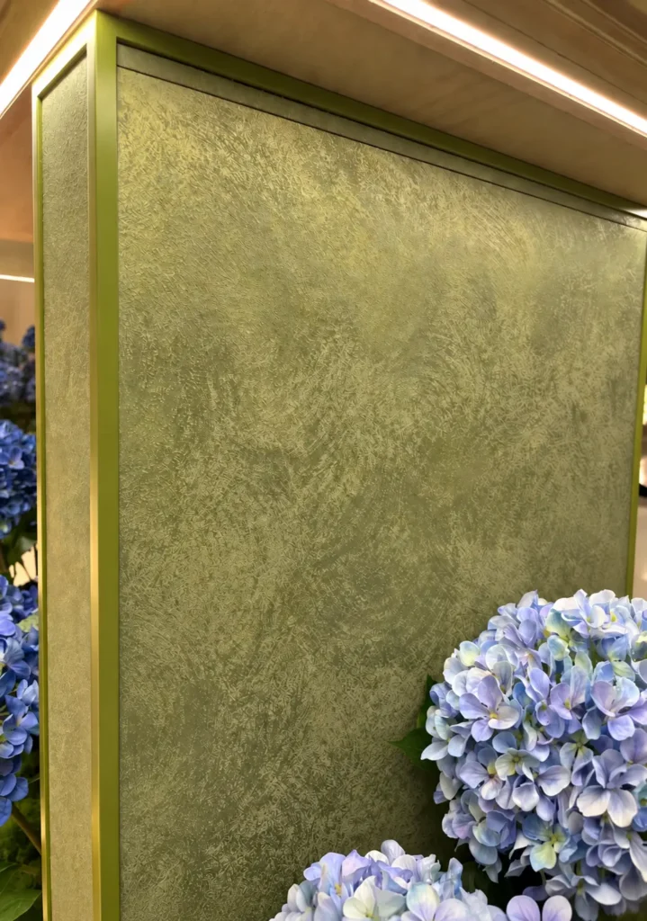 Olive Brass Flow flexible stone panel installed on a decorative interior wall with olive green metallic tones