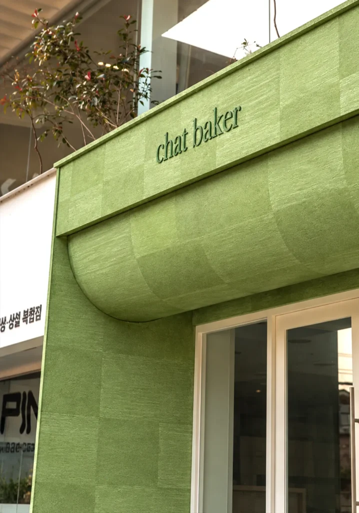 Sage Mist flexible stone veneer installed on a green storefront facade with curved cladding