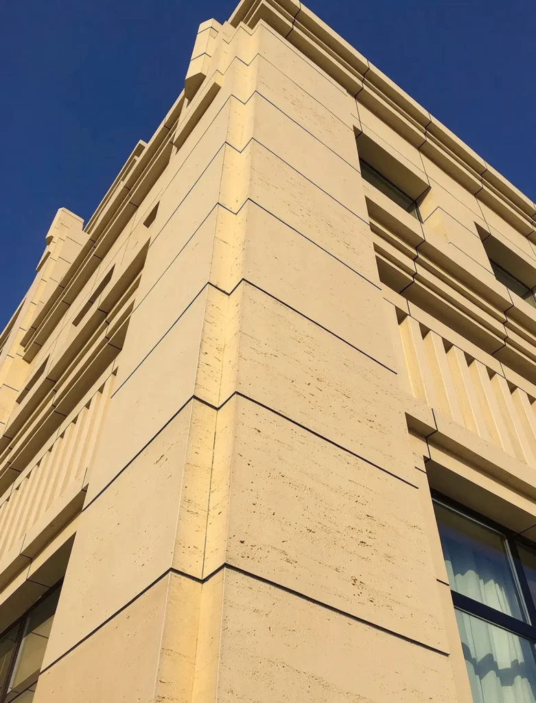 Corner detail of multi-story building with travertine MCM flexible stone veneer exterior cladding, Xinghai No.1 Hami