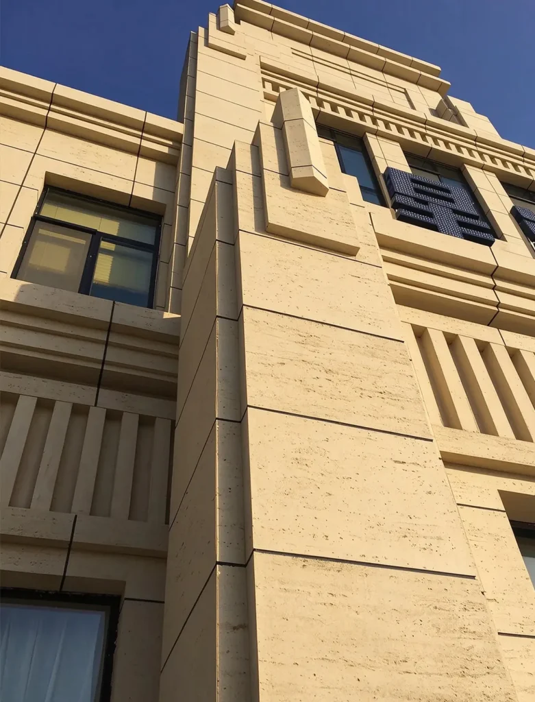 Travertine textured MCM flexible stone facade on multi-story building, architectural detail of Xinghai No.1 project in Hami Xinjiang