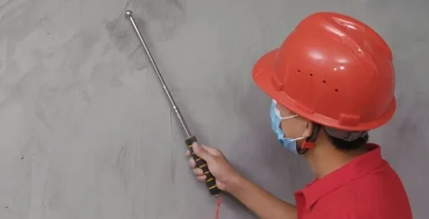 Installer inspecting the wall substrate before flexible stone installation.