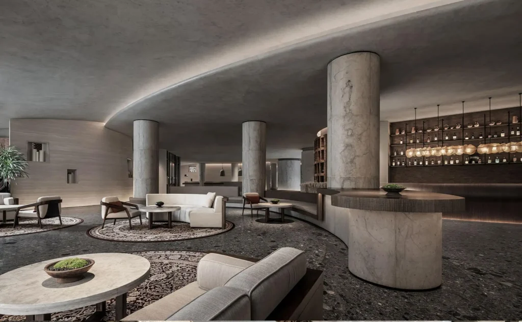 Completed hotel lobby featuring stone-look flexible cladding on cylindrical columns, curved reception counter and interior walls.